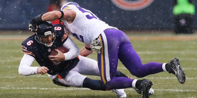 Jay Cutler # 6 des Bears de Chicago est abordé par Chad Greenway # 52 des Vikings du Minnesota au cours du deuxième quart d'un match au Soldier Field le 16 novembre 2014 à Chicago, Illinois.