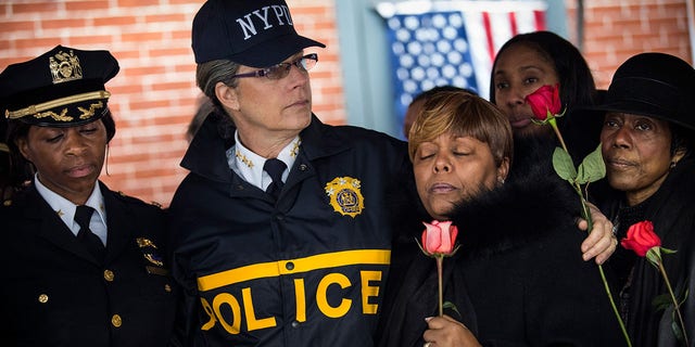 New York Police Department Bureau Chief Joanne Jaffe (C) sings hymns with members of Grandmothers LOV (Love over Violence), a group that works with the New York Police Department Community Affairs to end violence, after paying their respects at a memorial where two New York Police Department police officers who were shot and killed on December 23, 2014. 
