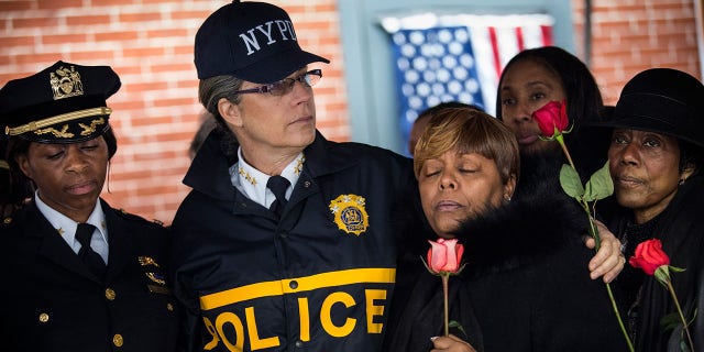 New York Police Department Bureau Chief Joanne Jaffe (C) sings hymns with members of Grandmothers LOV (Love over Violence), a group that works with the New York Police Department Community Affairs to end violence, after paying their respects at a memorial where two New York Police Department police officers who were shot and killed on December 23, 2014. 