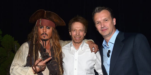 (L-R) Actor Johnny Depp, dressed as Captain Jack Sparrow and producer Jerry Bruckheimer of "Pirates of the Caribbean: Dead Men Tell No Tales" with President of Walt Disney Studios Motion Picture Production Sean Bailey.