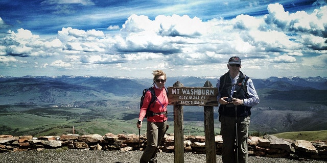 A couple poses at the summit of Mount Washburn. (Getty Images/Allison Achauer)