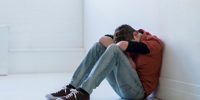 Foto di stock di un giovane depresso con la testa in giù.