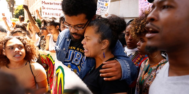LOS ANGELES, CA - JULY 12, 2016 - Melina Abdullah, a Cal State Los Angeles professor affiliated with the Black Lives Matter movement, right, hugs Marcus Vaughn, left, husband of Redel Jones, after she is released by police. (Photo by Al Seib/Los Angeles Times via Getty Images)