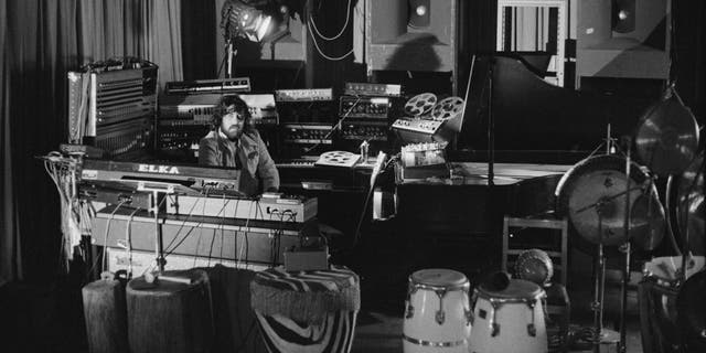 Vangelis, a Greek composer of electronic music, surrounded by equipment at a venue in 1976.