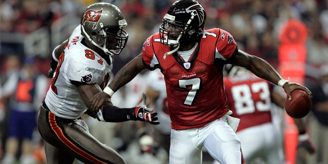 Michael Vick (7) of the Atlanta Falcons is bowled over by Simeon Rice (97) of the Tampa Bay Buccaneers during the Tampa Bay Buccaneers' 30-27 win over the Atlanta Falcons at the Georgia Dome in Atlanta, Georgia.