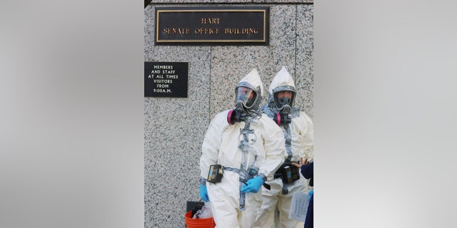 Members of a biohazard team wait to enter the Hart Senate Office Building Nov. 7, 2001, on Capitol Hill in Washington.
