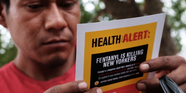A man reads an alert on fentanyl before being interviewed by John Jay College of Criminal Justice students.