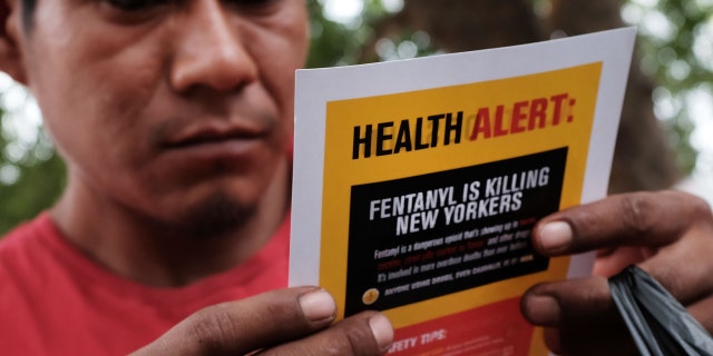 A man reads an alert on fentanyl before being interviewed by John Jay College of Criminal Justice students.