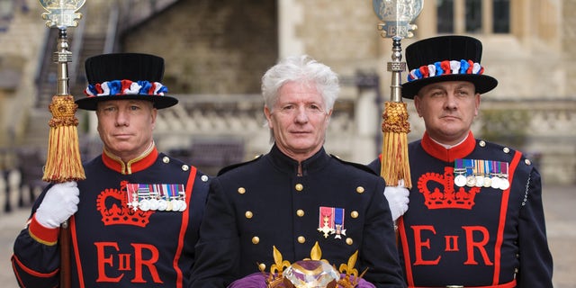 Pageant master of the Queen's Diamond Jubilee Beacons Bruno Peek, center, with the Jubilee Crystal Diamond, at the Tower of London, in central London, where the crystal is to be kept until Queen Elizabeth II's Diamond Jubilee celebrations. 