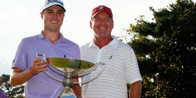 文件- Justin Thomas of the United States celebrates with his former coach from Alabama Jay Seawell on the 18th green after winning the FedExCup and second in the TOUR Championship during the final round at East Lake Golf Club on September 24, 2017 在亚特兰大, 佐治亚州.