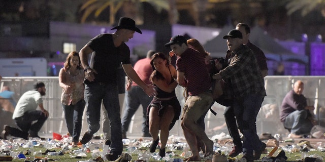Concertgoers rush to save a victim at the Route 91 Harvest country music festival at the Las Vegas Village on October 1, 2017 ラスベガスで, ネバダ.
