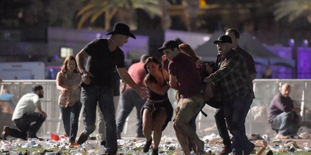 Concertgoers rush to save a victim at the Route 91 Harvest country music festival at the Las Vegas Village on October 1, 2017 in Las Vegas, Nevada.