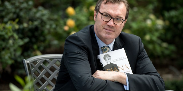 Andrew Morton poses with a copy of his book, "Diana: Her True Story - In Her Own Words," at his home in London on Aug. 24, 2017.