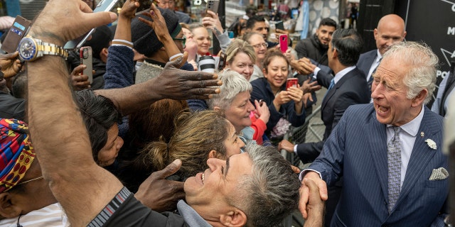 Prince Charles shakes hands and poses for selfies with members of the public in Walworth in south London on May 11, 2022.
