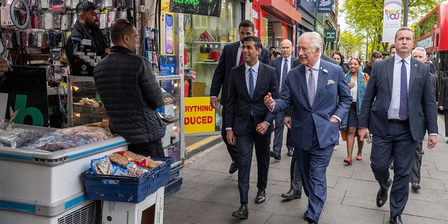 Chancellor of the Exchequer Rishi Sunak and Prince Charles chat with shop owners in south London on May 11, 2022.