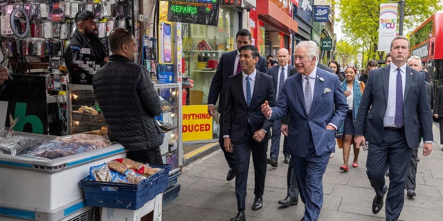 Chancellor of the Exchequer Rishi Sunak and Prince Charles chat with shop owners in south London on May 11, 2022.