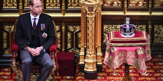 Prince William, Duke of Cambridge, sits by The Imperial State Crown in the House of Lords Chamber, during the State Opening of Parliament at the Palace of Westminster on May 10, 2022, in London, England.