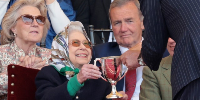 Queen Elizabeth II receives the winners cup at The Royal Windsor Horse Show at Home Park on May 13, 2022, in Windsor, England.