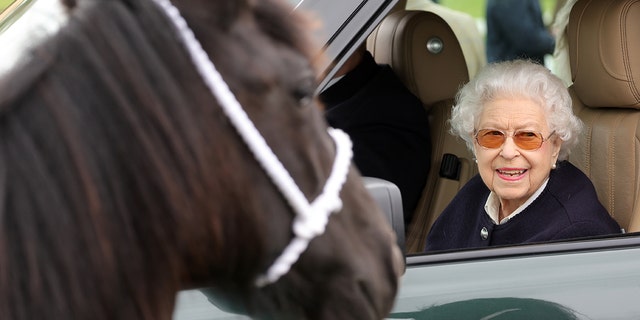 La reine Elizabeth II regarde les chevaux de son Range Rover au Royal Windsor Horse Show à Home Park le 13 mai 2022, à Windsor, en Angleterre. 