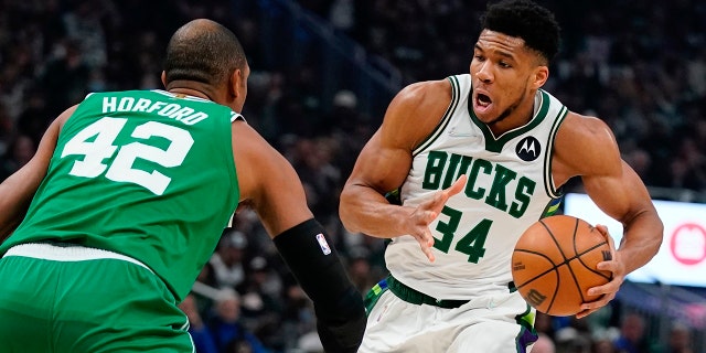 Milwaukee Bucks' Giannis Antetokounmpo drives past Boston Celtics' Al Horford during the first half of Game 3 of an NBA basketball Eastern Conference semifinals playoff series Saturday, 五月 7, 2022, ミルウォーキーで.