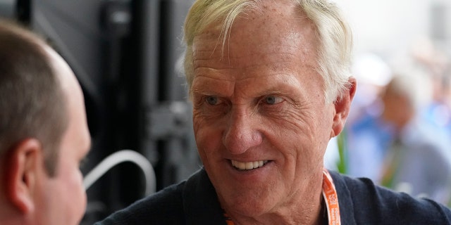Professional golfer Greg Norman walks through the pit area during the third practice session for the Formula One Miami Grand Prix auto race at the Miami International Autodrome, Saturday, May 7, 2022, in Miami Gardens, Fla.