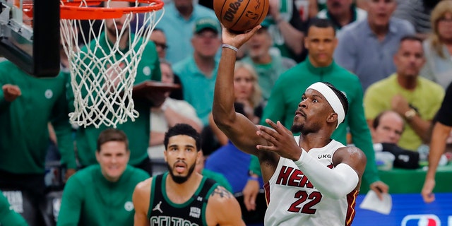 Miami Heat's Jimmy Butler (22) shoots against Boston Celtics' Jayson Tatum (0) during the second half of Game 6 of the NBA basketball playoffs Eastern Conference finals Friday, May 27, 2022, in Boston. (AP Photo/Michael Dwyer)