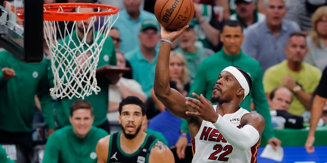 Miami Heat's Jimmy Butler (22) shoots against Boston Celtics' Jayson Tatum (0) during the second half of Game 6 of the NBA basketball playoffs Eastern Conference finals Friday, May 27, 2022, in Boston. (AP Photo/Michael Dwyer)