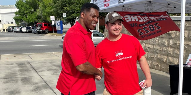 Republican Senate candidate Herschel Walker shakes hands with a supporter at a campaign event in Valdosta, Georgia, on May 21, 2022