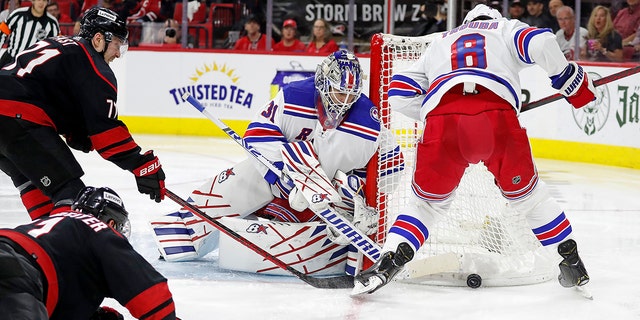 New York Rangers goaltender Igor Shesterkin (31) and teammate Jacob Trouba (8) control the puck in front of Carolina Hurricanes' Jesper Fast (71) and Nino Niederreiter (21) during the second period of Game 1 of an NHL hockey Stanley Cup second-round playoff series in Raleigh, N.C., Wednesday, May 18, 2022.