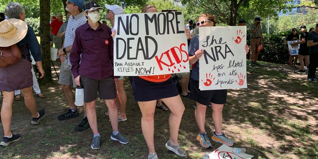 Protesters stand outside the NRA convention in Texas.