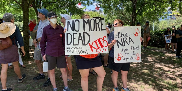 Protesters stand outside the NRA convention in Texas.