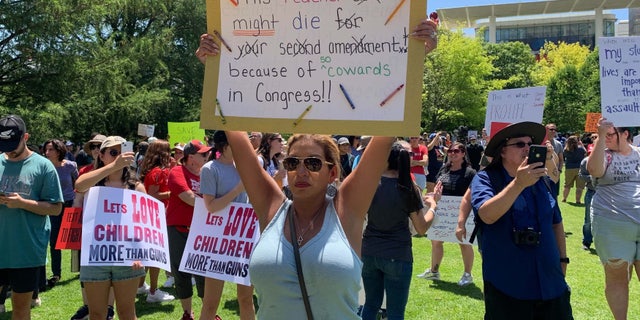 Protesters stand outside the NRA convention in Texas.