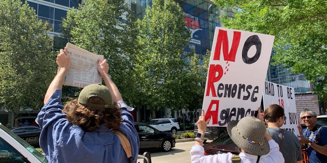 Protesters stand outside the NRA convention in Texas.