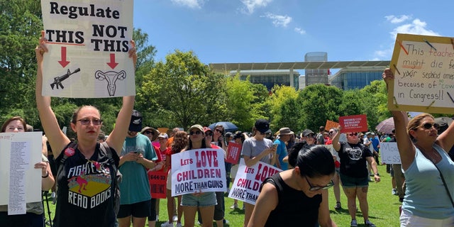 Protesters stand outside the NRA convention in Texas.