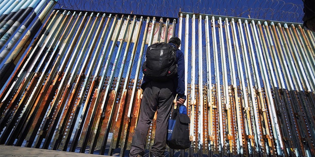 FILE: Seorang migran menunggu di sisi perbatasan Meksiko setelah petugas Bea Cukai dan Perlindungan Perbatasan Amerika Serikat menahan beberapa migran yang melintasi perbatasan AS-Meksiko di pantai, di Tijuana, Meksiko, 26 Januari 2022. 