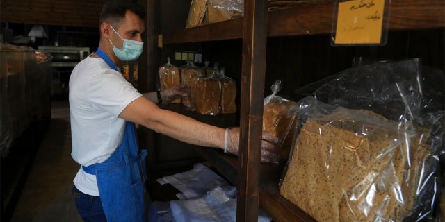 Bakery worker Mojtaba Motallebi put bread packs in shelves at a bakery in Tehran, Iran, Wednesday, May 11, 2022.