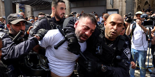 Members of the Israeli security forces detain a man during the funeral of Al Jazeera reporter Shireen Abu Akleh, who was killed during an Israeli raid in Jenin in the occupied West Bank, in Jerusalem, May 13, 2022.