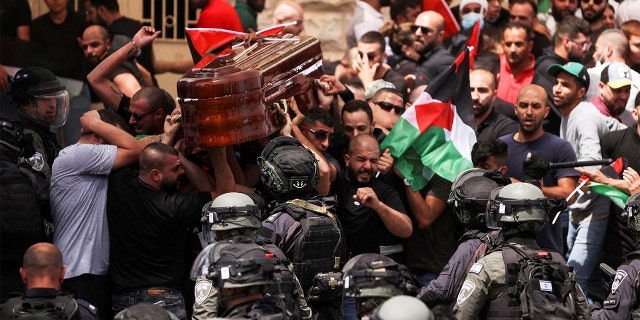 Family and friends carry the coffin of Al Jazeera reporter Shireen Abu Akleh, who was killed during an Israeli raid in Jenin in the occupied West Bank, as clashes erupted with Israeli security forces, during her funeral in Jerusalem, May 13, 2022.