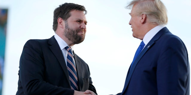 Senate candidate J.D. Vance greets former President Donald Trump at a rally Saturday, April 23, 2022, in Delaware, Ohio.