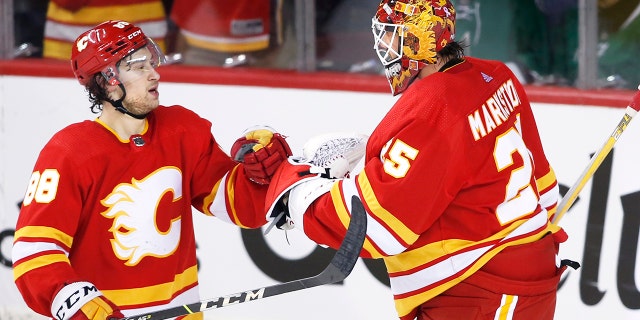 Calgary Flames left wing Andrew Mangiapane (88) and goaltender Jacob Markstrom (25) celebrate defeating the Dallas Stars in Game 5 of an NHL hockey Stanley Cup first-round playoff series, Wednesday, May 11, 2022 in Calgary, Alberta.