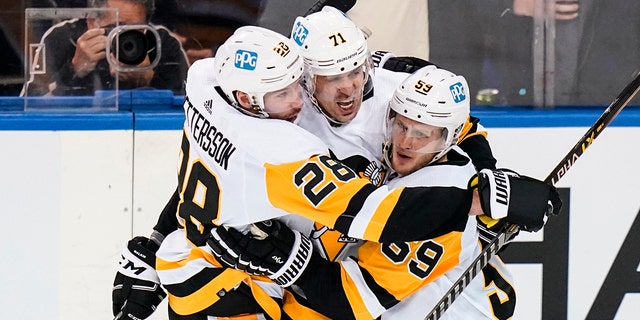 Pittsburgh Penguins' Jake Guentzel (59) celebrates with teammates Marcus Pettersson (28) and Evgeni Malkin (71) after scoring a goal during the second period of Game 5 of an NHL hockey Stanley Cup first-round playoff series against the New York Rangers  Wednesday, May 11, 2022, in New York. 