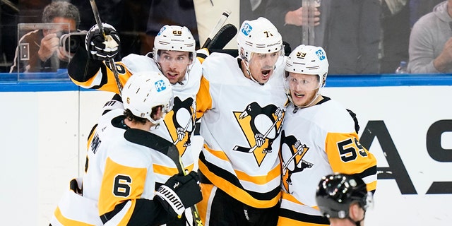 Pittsburgh Penguins' Jake Guentzel (59) celebrates with teammates Evgeni Malkin (71), Marcus Pettersson (28) and John Marino (6) after scoring a goal during the second period of Game 5 of an NHL hockey Stanley Cup first-round playoff series against the New York Rangers Wednesday, May 11, 2022, in New York.