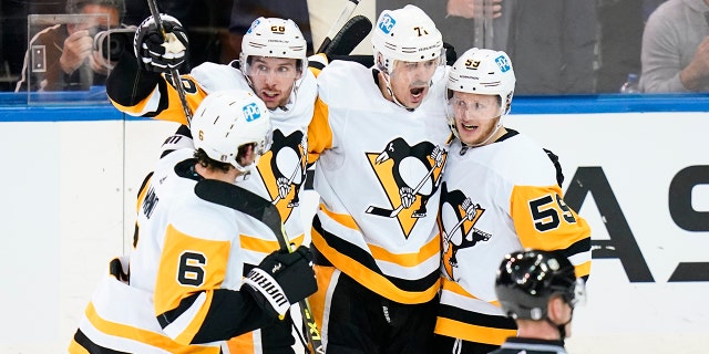 Pittsburgh Penguins' Jake Guentzel (59) celebrates with teammates Evgeni Malkin (71), Marcus Pettersson (28) and John Marino (6) after scoring a goal during the second period of Game 5 of an NHL hockey Stanley Cup first-round playoff series against the New York Rangers Wednesday, May 11, 2022, in New York.
