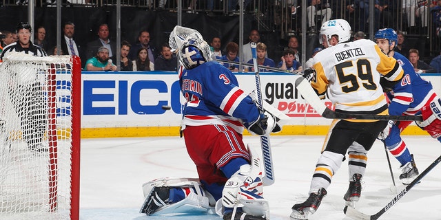 Jake Guentzel #59 of the Pittsburgh Penguins knocks the puck past goaltender Igor Shesterkin #31 of the New York Rangers during the second period in Game Seven of the First Round of the 2022 Stanley Cup Playoffs at Madison Square Garden on May 15, 2022 in die stad New York.