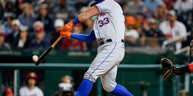 James McCann of the New York Mets hits a sacrificial fly during the sixth inning of a baseball game against the Washington Nationals at Nationals Park on Tuesday, May 10, 2022 in Washington.