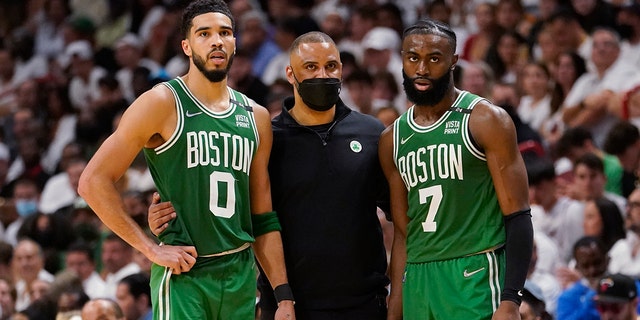 Boston Celtics head coach Ime Udoka speaks to Boston Celtics forward Jayson Tatum (0) and guard Jaylen Brown (7) during the second half of Game 1 of an NBA basketball Eastern Conference finals playoff series against the Miami Heat, Tuesday, May 17, 2022, in Miami.