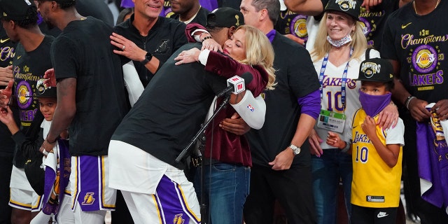 LeBron James hugs Jeanie Buss as the Los Angeles Lakers celebrate after winning their sixth game of the NBA Finals against the Miami Heat on Oct.18, 2020, in Orlando, Florida at AdventHealth Arena.
