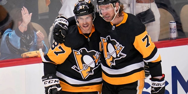 Pittsburgh Penguins' Jeff Carter (77) celebrates his second goal, an empty-net goal during the third period, with Sidney Crosby in Game 3 of an NHL hockey Stanley Cup first-round playoff series against the New York Rangers in Pittsburgh, Saturday, May 7, 2022.