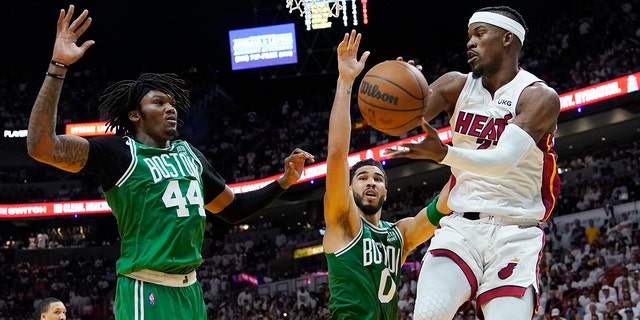 Boston Celtics center Robert Williams III (44) 和前锋杰森·塔图姆 (0) attempt to block a pass by Miami Heat forward Jimmy Butler (22) during the second half of Game 1 of an NBA basketball Eastern Conference finals playoff series, 星期二, 可能 17, 2022, 在迈阿密.