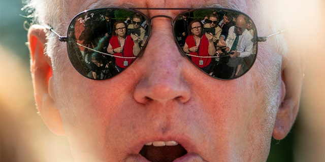 Members of the media are visible in the sunglasses of President Biden as he speaks on the South Lawn of the White House Monday, May 30, 2022.